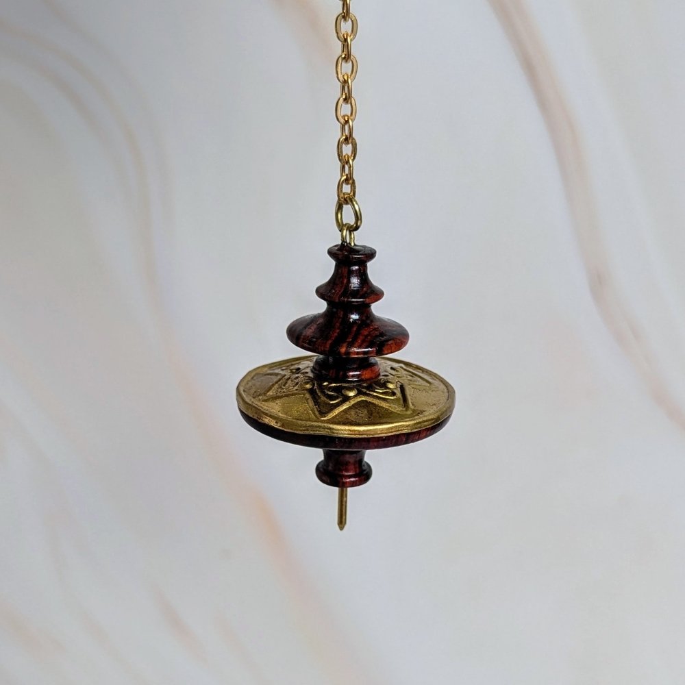 Le pendule Mystica, inspiré du Moyen Âge, combine bois précieux et laiton. Il est repoussé pour un design unique basé sur l’étoile à 7 branches. Conçu pour des recherches spirituelles profondes, il est idéal pour l’astrologie, la magie, l’alchimie, la numérologie et l’étude des textes kabbalistiques. Son centre de gravité situé en haut lui confère une très haute sensibilité. Il amplifie chaque mouvement et offrant ainsi des réponses précises et franches.